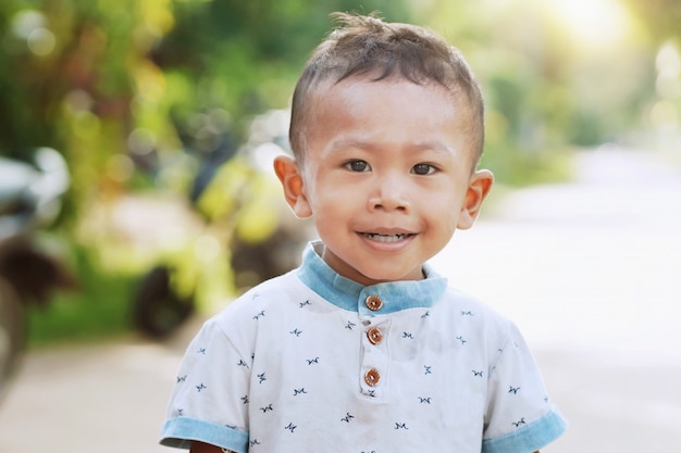 Niños asiáticos de pie sonriendo en la luz de la mañana