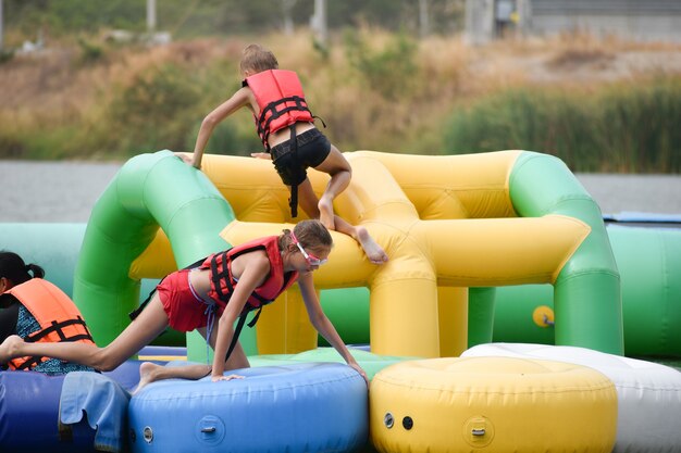 niños en atracciones acuáticas inflables.