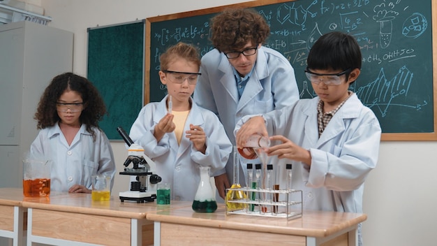 Niños atractivos haciendo experimentos en la lección de ciencias en el laboratorio Pedagogía