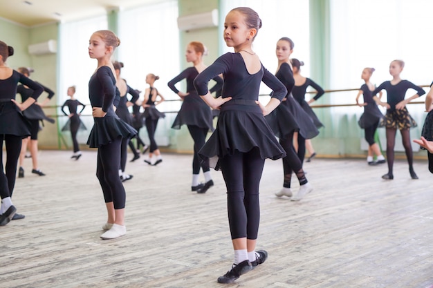 Los niños bailan con un entrenador en una gran sala de entrenamiento.