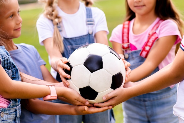 Niños con balón de fútbol en las manos