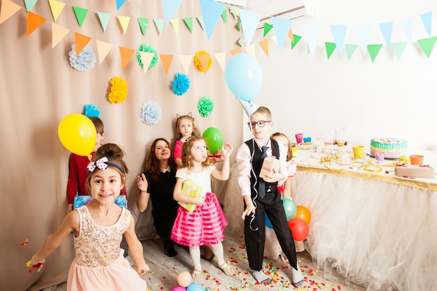 Los niños brillantes celebran la fiesta de cumpleaños de sus amigos