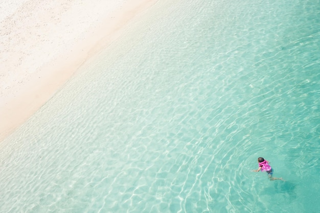 Niños buceando y relajándose en aguas cristalinas y turquesas del mar tropical