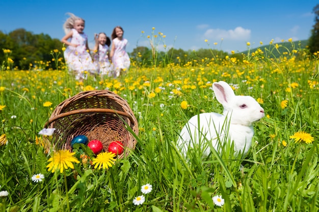 Niños en búsqueda de huevos de Pascua con conejito