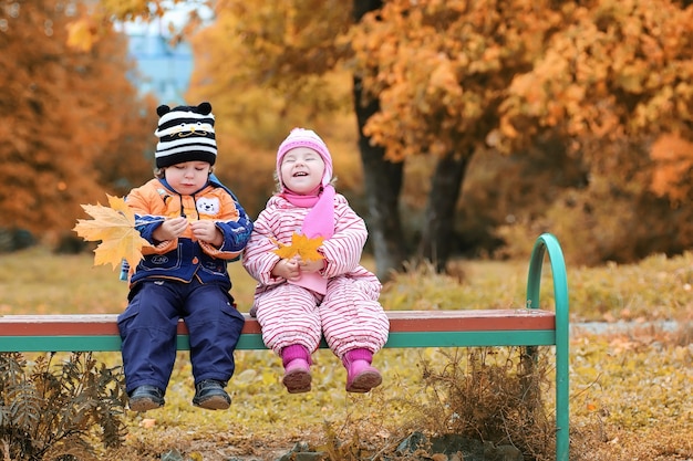 Los niños en la calle juegan otoño.