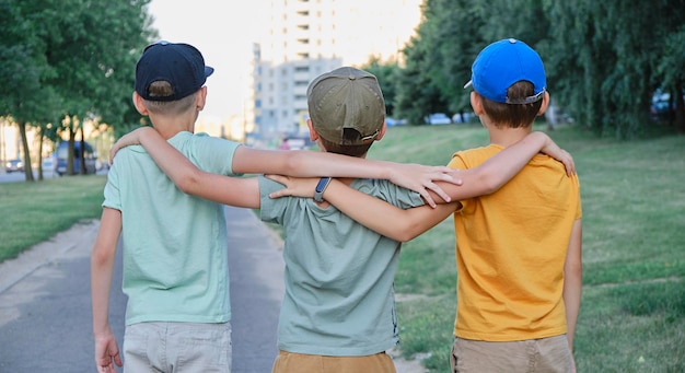 Los niños caminan en un abrazo en la calle una vista desde atrás Concepto social