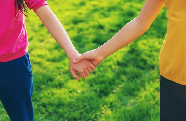 Foto los niños caminan juntos cogidos de la mano enfoque selectivo