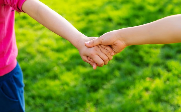 Foto los niños caminan juntos cogidos de la mano enfoque selectivo