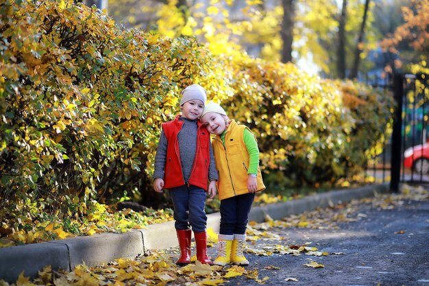 Los niños caminan en el parque de otoño en el otoño.