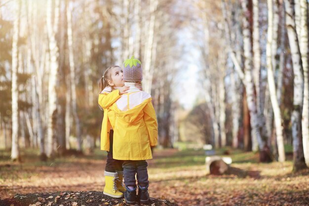 Los niños caminan en el parque de otoño en el otoño.