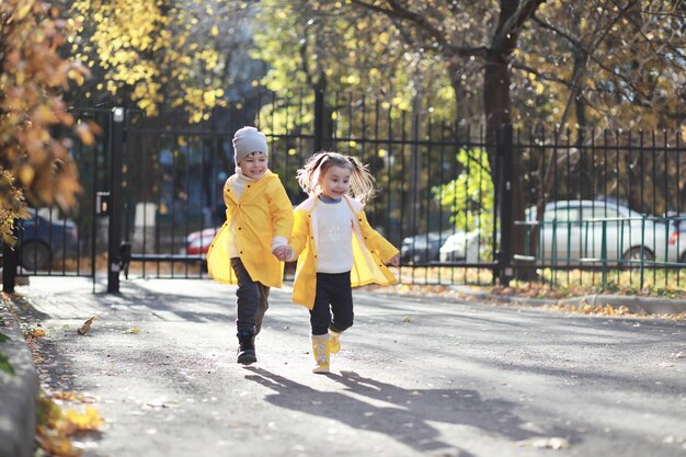 Los niños caminan en el parque de otoño en el otoño.