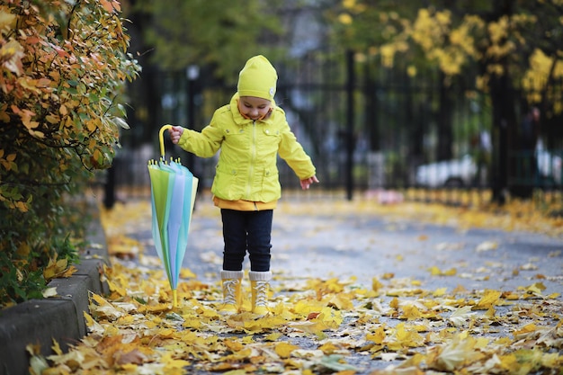 Los niños caminan en el parque de otoño en el otoño.