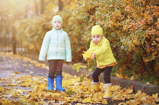 Los niños caminan en el parque de otoño en el otoño.