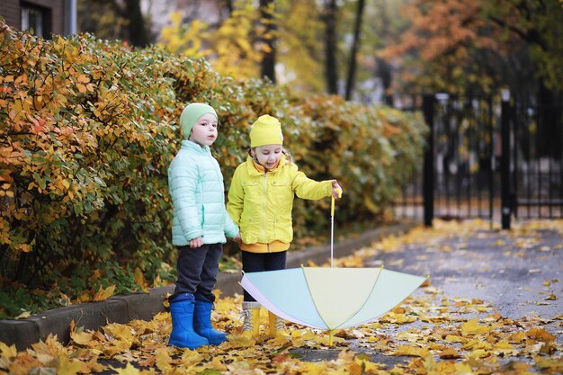 Los niños caminan en el parque de otoño en el otoño.