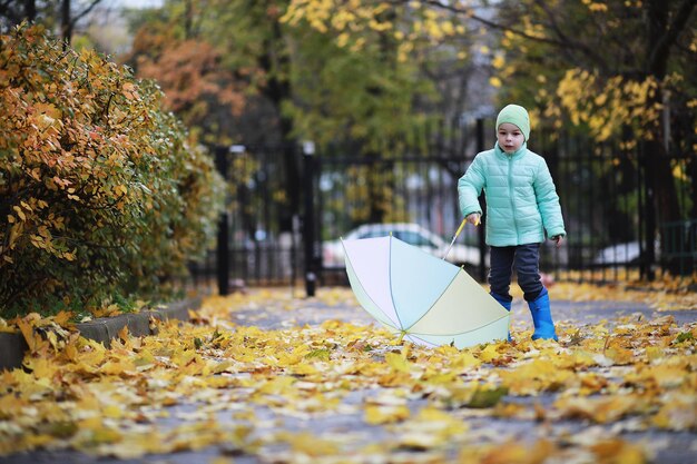 Los niños caminan en el parque de otoño en el otoño.