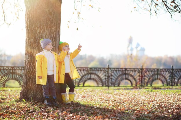 Los niños caminan en el parque de otoño en el otoño.