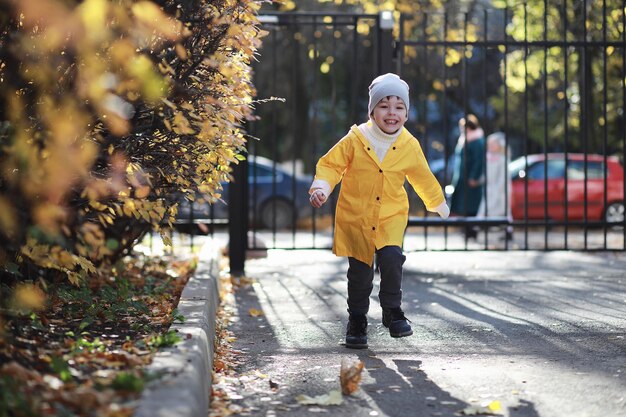 Los niños caminan en el parque de otoño en el otoño.