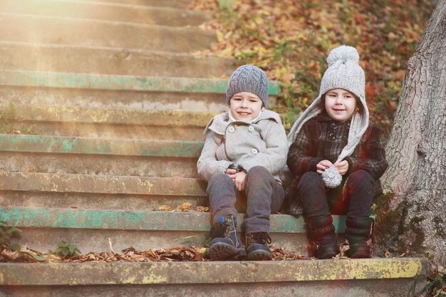 Los niños caminan en el parque de otoño en el otoño.