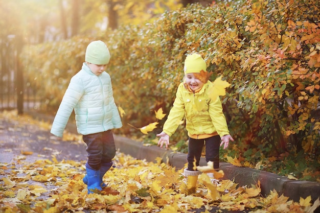 Los niños caminan en el parque de otoño en el otoño.