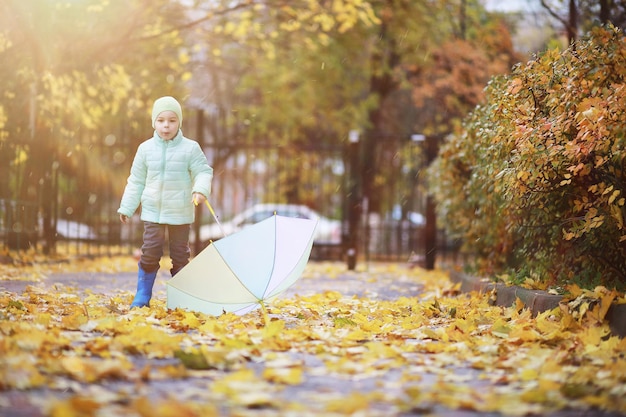 Los niños caminan en el parque de otoño en el otoño.