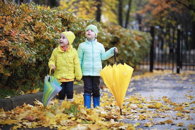 Los niños caminan en el parque de otoño en el otoño.