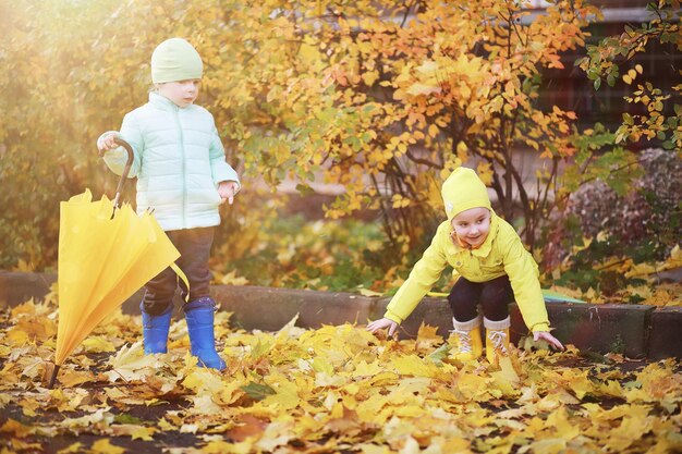 Los niños caminan en el parque de otoño en el otoño.