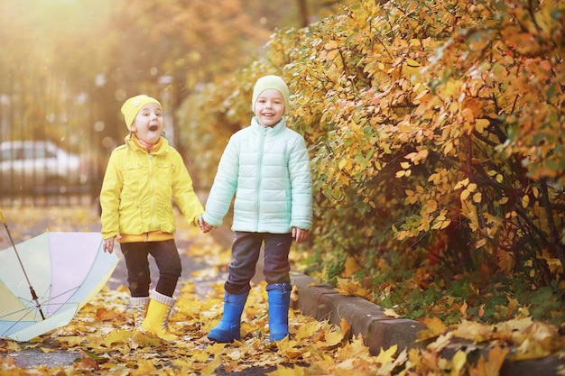 Los niños caminan en el parque de otoño en el otoño.