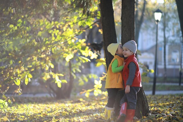 Los niños caminan en el parque de otoño en el otoño.