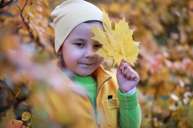 Los niños caminan en el parque de otoño en el otoño.