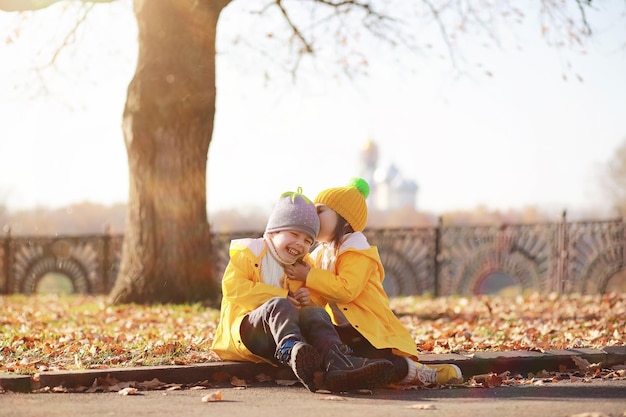 Los niños caminan en el parque de otoño en el otoño.