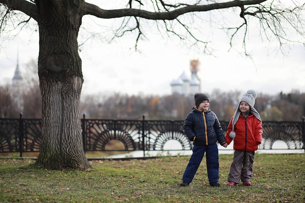 Los niños caminan en el parque de otoño en el otoño.