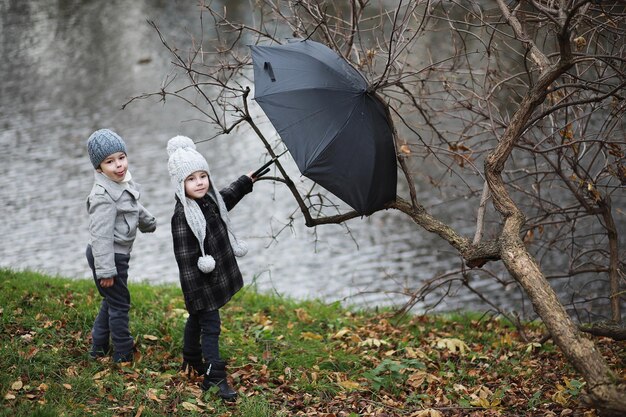 Los niños caminan en el parque de otoño en otoñoxA