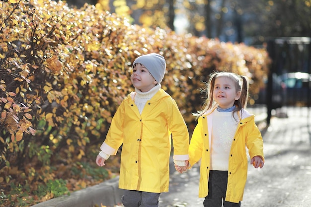 Los niños caminan en el parque de otoño.