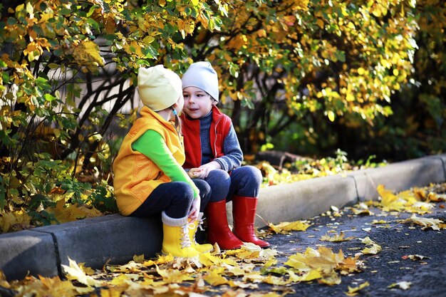 Los niños caminan en el parque de otoño.