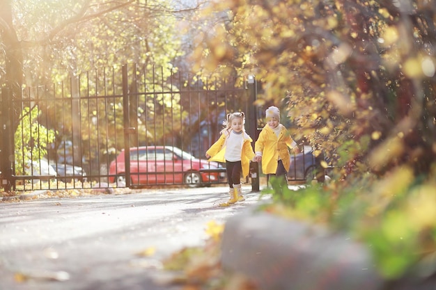 Los niños caminan en el parque de otoño.