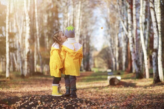 Los niños caminan en el parque de otoño.