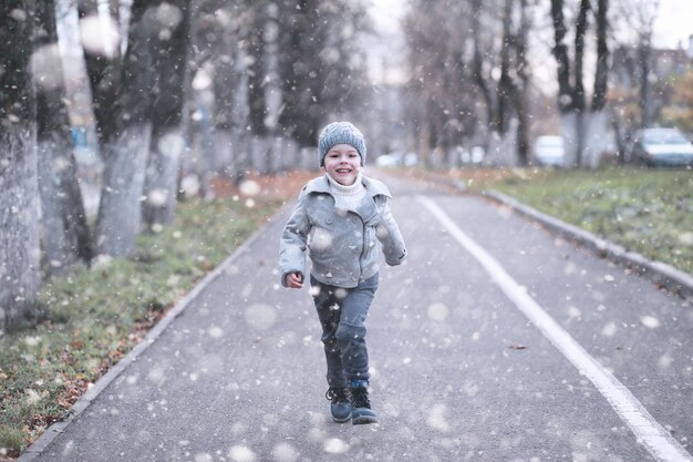 Los niños caminan en el parque con la primera nevada