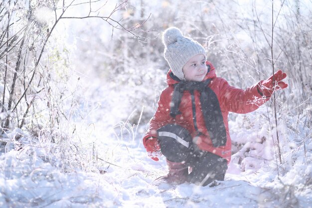 Los niños caminan en el parque con la primera nevada