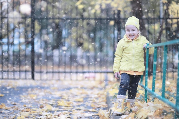 Los niños caminan en el parque primera nevada