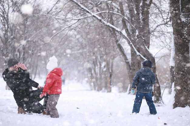 Los niños caminan en el parque primera nevada