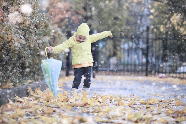 Los niños caminan en el parque primera nevada