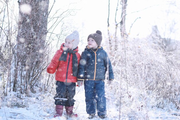 Los niños caminan en el parque primera nevada