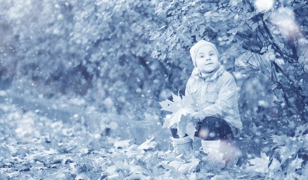 Los niños caminan en el parque con la primera nieve.