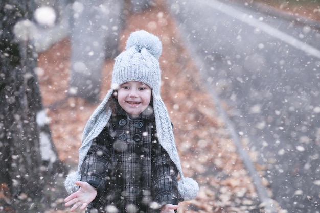 Los niños caminan por el parque con la primera nieve.