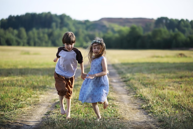 Los niños caminan en verano en la naturaleza Niño en una soleada mañana de primavera en el parque Viajar con niños