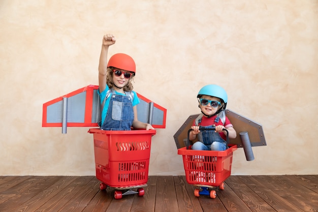 Niños con carreras de cohetes de papel en carrito de compras interior