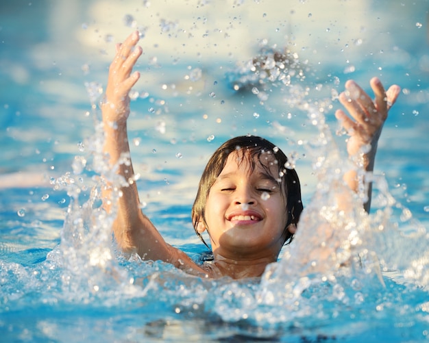 Niños chapoteando en la piscina de verano