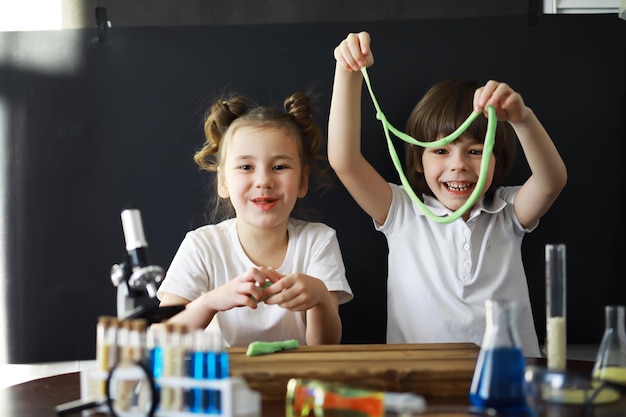 Niños científicos Escolares en el laboratorio realizan experimentos Experimentos de niños y niñas con un microscopio