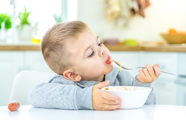 Niños en la cocina en la mesa girando el enfoque selectivo de pasta