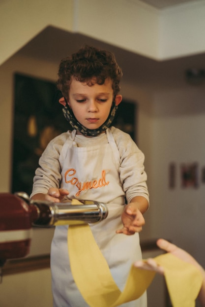 los niños cocinan pasta en una clase magistral de gastronomía